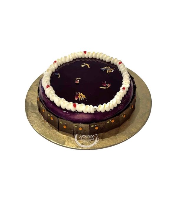 Base di crumble al cacao, una gelè alla mora, cassis e sambuco, e una crema namelaka al cioccolato bianco. la camicia della torta fatta con panna vanigliata. Il tutto glassato con una glassa viola neutra.